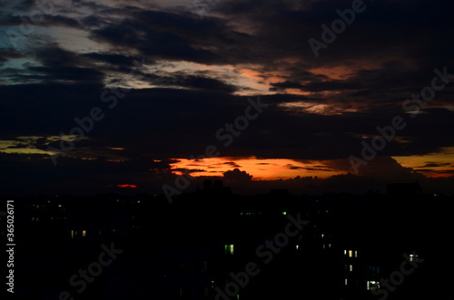 Beautiful and dramatic sky with clouds over the city with a blurred view at Savar, Bangladesh. Blur Background with golden and reddish sunset abstract. sunset in the city with shadows of buildings