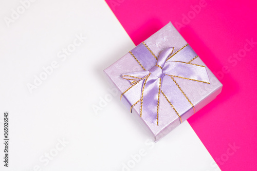 Gift on a multicolored background. Surprise in a festive package.