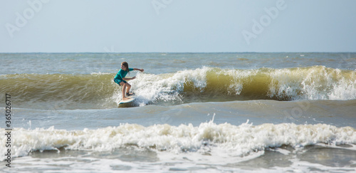 Photography Panoramic shot of talented kid surfing waves on the Atlantic Ocean