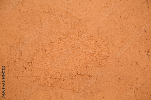 close-up of the clay wall of a terracotta-colored village house, texture