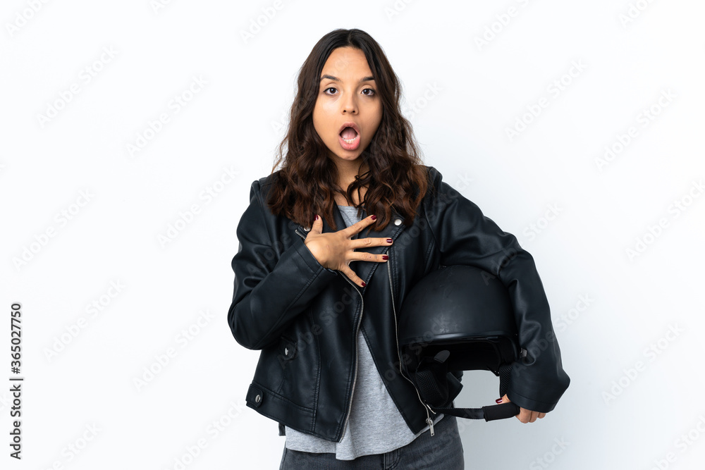 Young woman holding a motorcycle helmet over isolated white background surprised and shocked while looking right Young woman holding a motorcycle helmet over isolated white background surprised and shocked while looking right