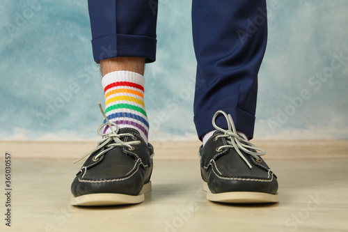Man in blue pant  loafers and LGBT socks against blue background