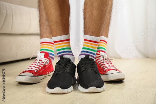 Gay couple in LGBT socks standing together indoor