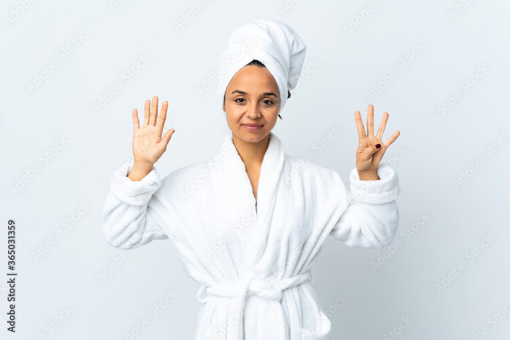 Young woman in bathrobe over isolated white background counting nine with fingers Young woman in bathrobe over isolated white background counting nine with fingers