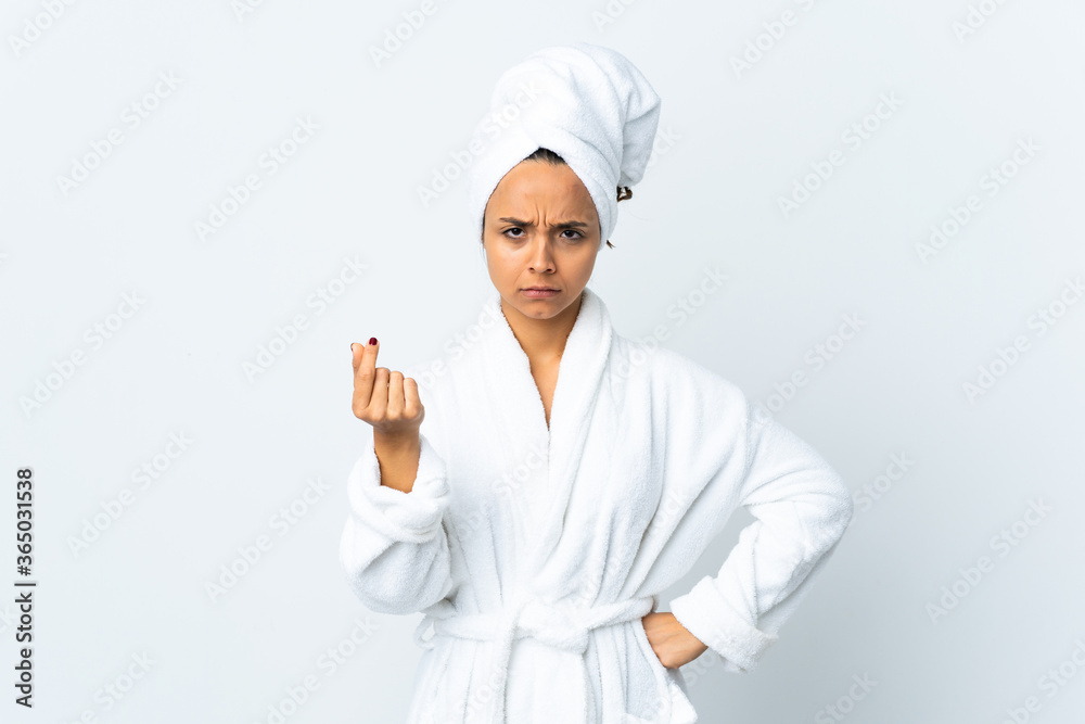 Young woman in bathrobe over isolated white background making money gesture but is ruined Young woman in bathrobe over isolated white background making money gesture but is ruined
