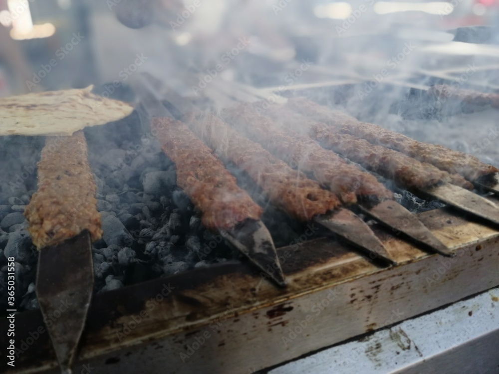 Cooking Adana kebabs on the restaurant style grill Cooking Adana kebabs on the restaurant style grill