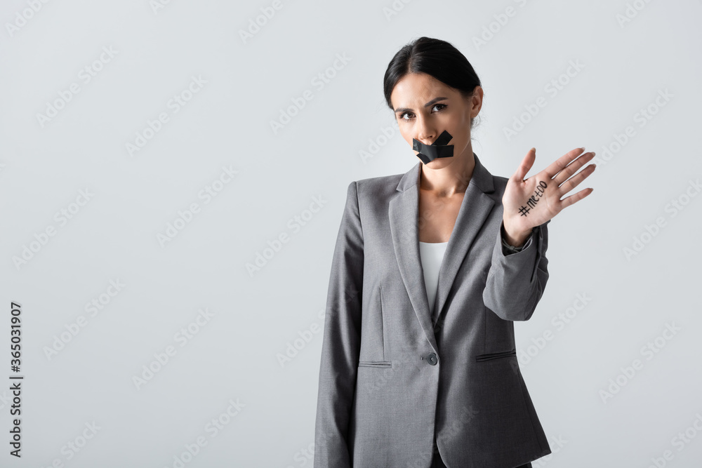 businesswoman with scotch tape on mouth showing hand with me too lettering isolated on white, gender inequality concept businesswoman with scotch tape on mouth showing hand with me too lettering isolated on white, gender inequality concept