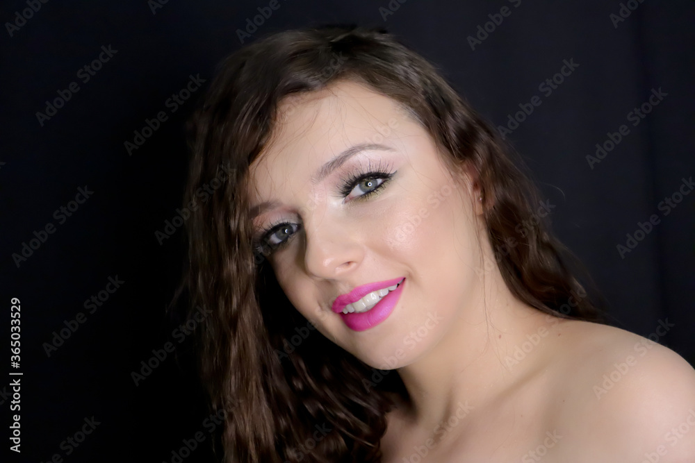 close up portrait of beautiful brunette young girl happily smiling, looking at camera with fresh make up on black background, pink lipstick curly hair over bare, naked shoulders, studio shot, close up portrait of beautiful brunette young girl happily smiling, looking at camera with fresh make up on black background, pink lipstick curly hair over bare, naked shoulders, studio shot,
