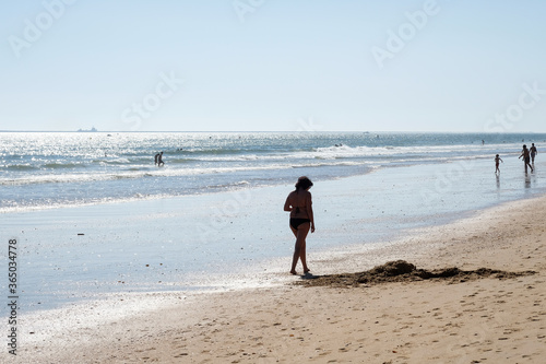 Mujer paseando por la playa photo