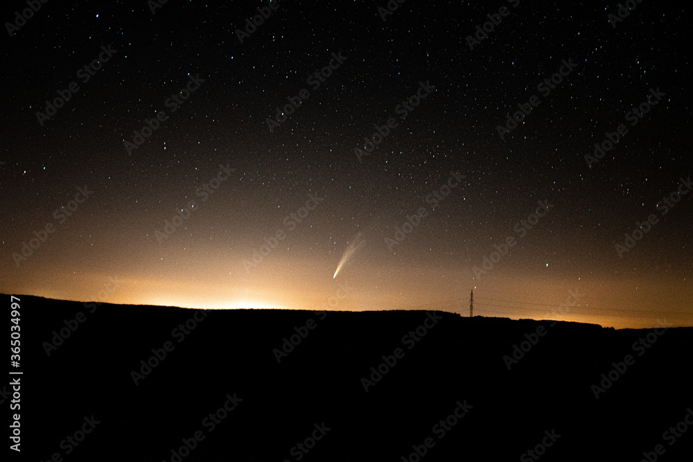 Comet Neowise C/2020 flying over the hills with stars and Milky Way on the night sky Comet Neowise C/2020 flying over the hills with stars and Milky Way on the night sky