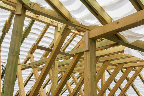 Wooden roof construction. Wooden House Frame. Roof support beams in home under construction