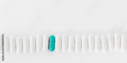 Vitamin supplements in white and green capsules