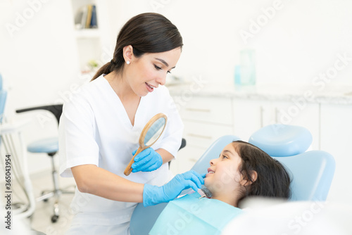 Dentist Examining Girl At Clinic