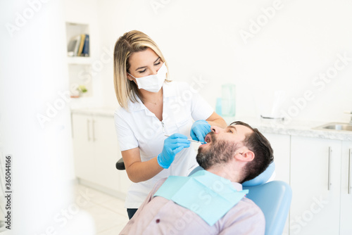 Orthodontist Examining Mid Adult Man