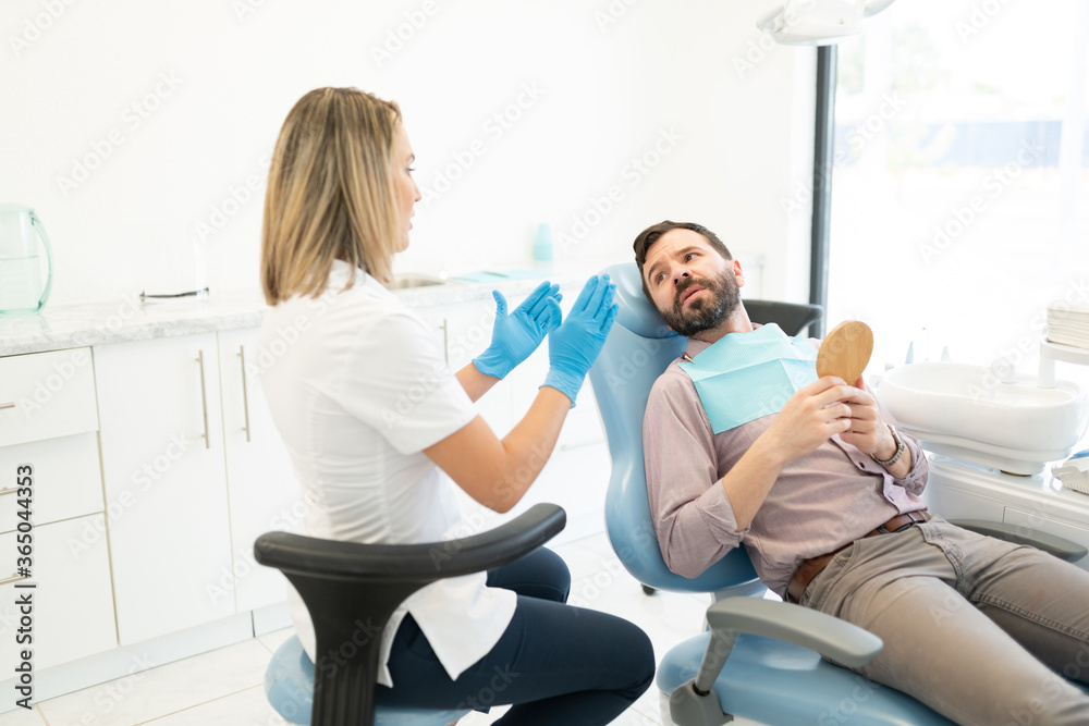 Dentist Explaining Patient At Clinic Dentist Explaining Patient At Clinic