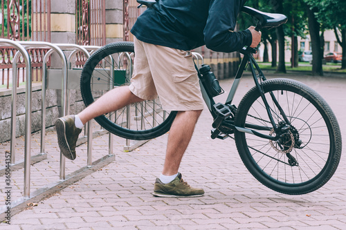 Man steals an unfastened bicycle in the city.