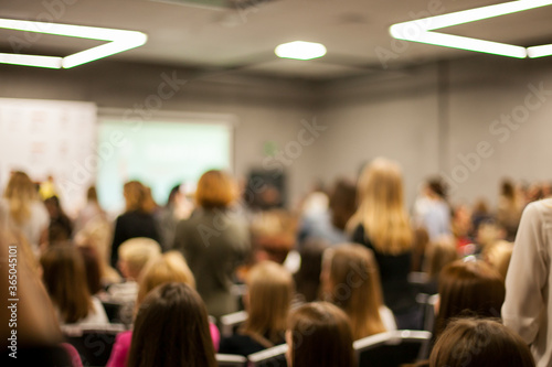 Abstract blurred photo of conference hall or seminar room with speakers on the stage and attendee background, seminar and study concept. Speaker on the podium. People at the conference hall. photo