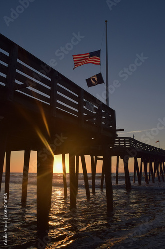 American Flag and POW MIA Flag Fly at Sunrise on Fishing Pier in Ocean City NJ at Sunrise on the Beach © Alex