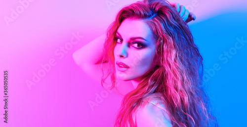 High Fashion. Woman in colorful neon light, make-up. Sexy girl, stylish wet hair, trendy makeup. Party disco neon style. Creative art beauty portrait, fashionable model face, bright make up