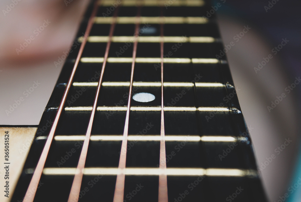 Close-up of a guitar neck with six strings. Close-up of a guitar neck with six strings.