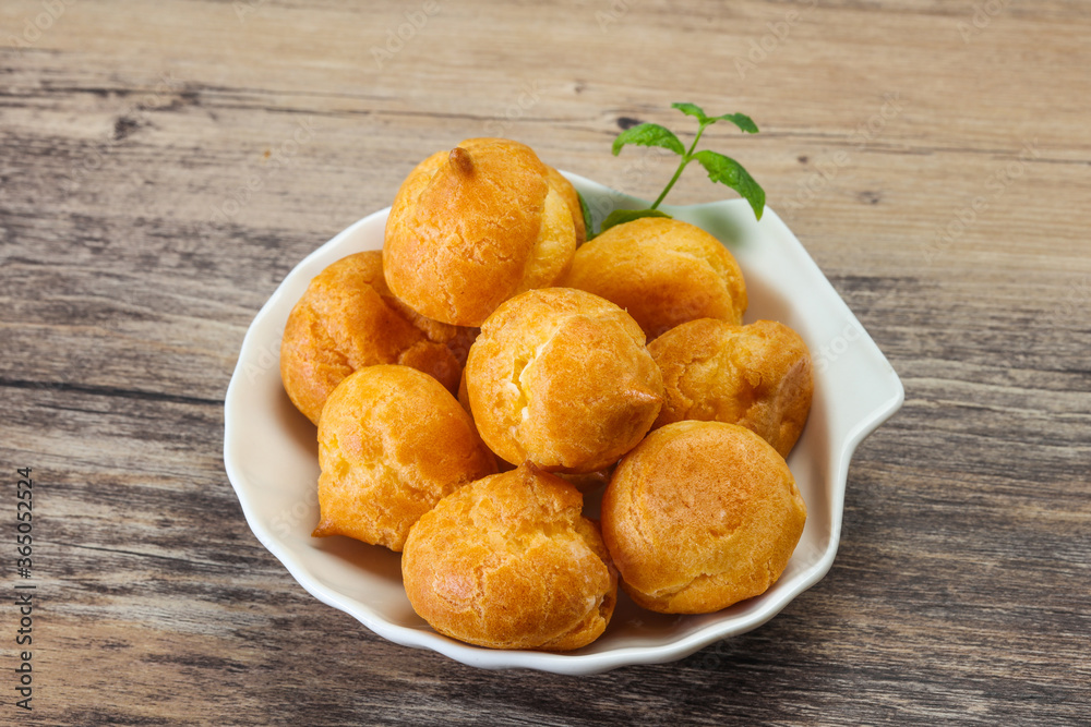 Sweet tasty profiteroles heap in the bowl Sweet tasty profiteroles heap in the bowl