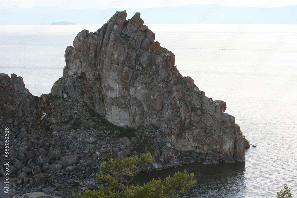 Baikal Lake in summer. View of the natural landmark of Olkhon Island - Shamanka Rock. Lake natural background. Beautiful landscape background with copy space