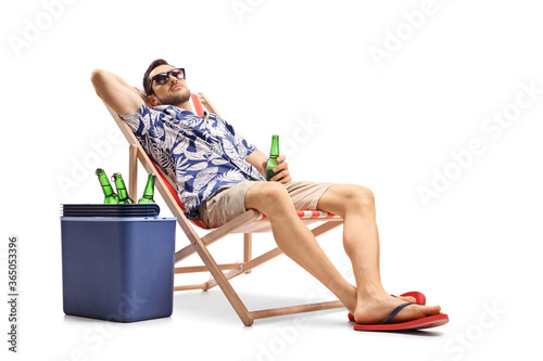 Wallpaper Mural Guy holding a bottle of beer on a deckchair with a cooling box beside