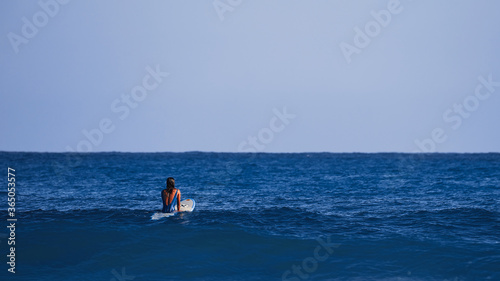 Surfer girl waiting for a wave. Surfer school. Beautiful young woman in swimsuit goes into ocean in hot summer day. Surfer on the wave. beautiful ocean wave. Water sport activity