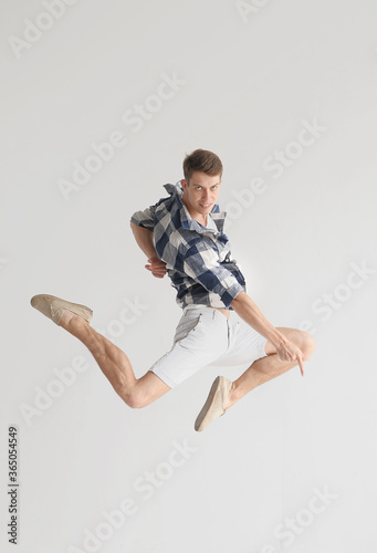 Stylish dancer man jumping in light syudio photo