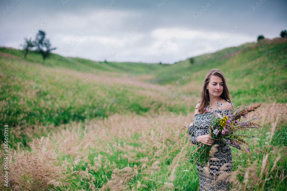Beautiful, slender girl in a meadow dress with wildflowers Beautiful, slender girl in a meadow dress with wildflowers