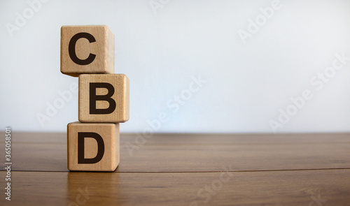 Wood blocks with acronym 'CBD' - 'customer business development' on wooden table. White background, copy space. Business concept.