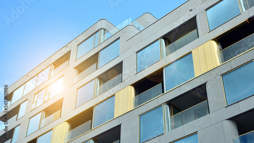 Modern apartment buildings on a sunny day with a blue sky. Facade of a modern apartment building. Glass surface with sunlight.