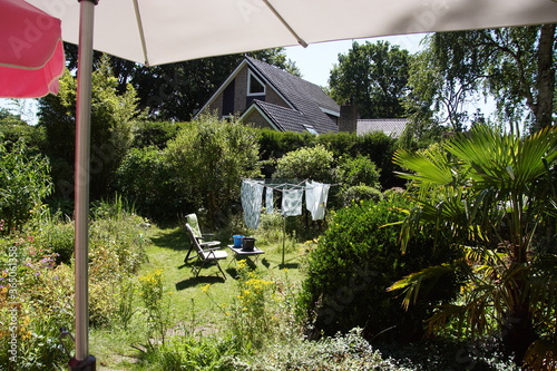 The laundry on the line of a rotary umbrella clothesline in the lawn in a Dutch garden. Summer, the Netherlands. photo