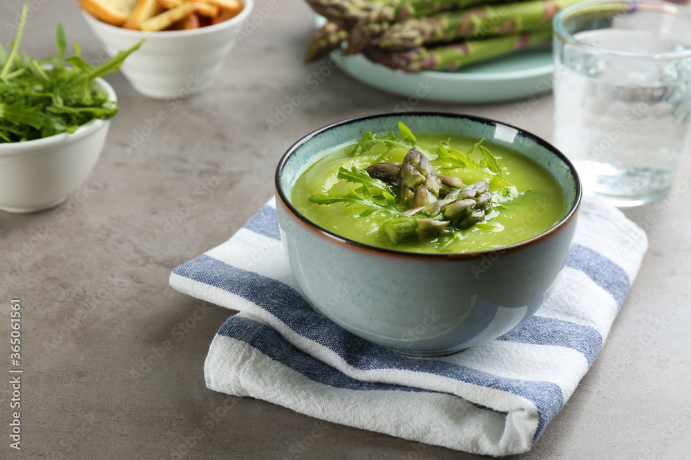 Delicious asparagus soup served on grey table Delicious asparagus soup served on grey table