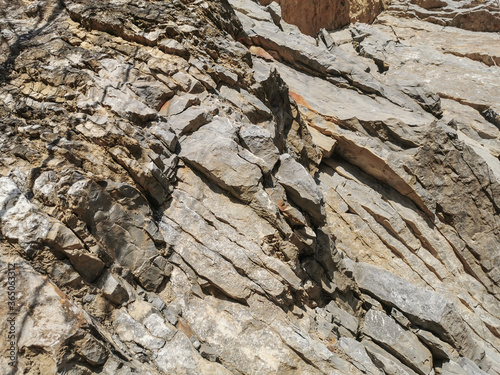 Mountain mineral rock shale with a parallel layered arrangement of yellow and gray minerals in their natural form.Landscape design. Finishing work. Geology. Construction.Minerals