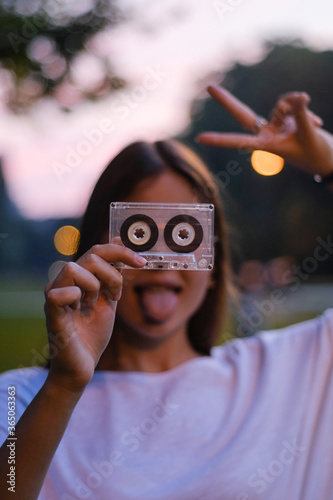 Young girl portrait fooling around with an audiotape