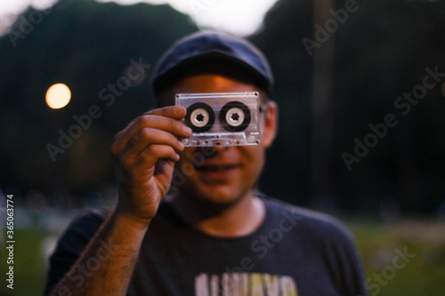 Funny portrait of a young man with an audio cassette 