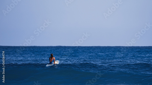 Surfer girl waiting for a wave. Surfer school. Beautiful young woman in swimsuit goes into ocean in hot summer day. Surfer on the wave. beautiful ocean wave. Water sport activity