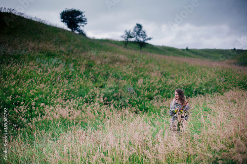 Beautiful, slender girl in a meadow dress with wildflowers © Denis