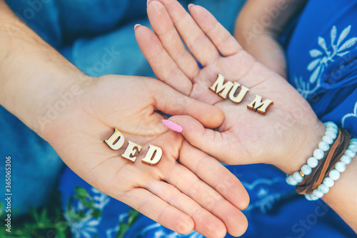 A man and a woman are holding letters in the hands of ded and mum. Selective focus. photo