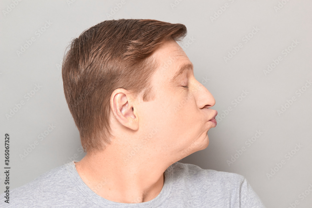 Portrait of funny mature man pouting his lips and blowing kiss Portrait of funny mature man pouting his lips and blowing kiss