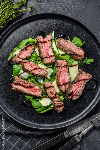 Steak salad with spinach, arugula and sliced beef Striploin steak. Black background. Top view