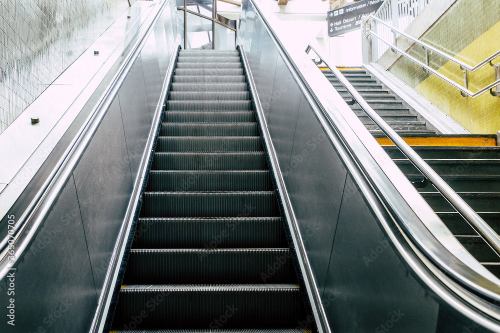 Escalator en métal dans une gare - Perspective sur les marches qui montent Escalator en métal dans une gare - Perspective sur les marches qui montent
