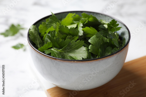 Fresh green parsley on white marble table, closeup
