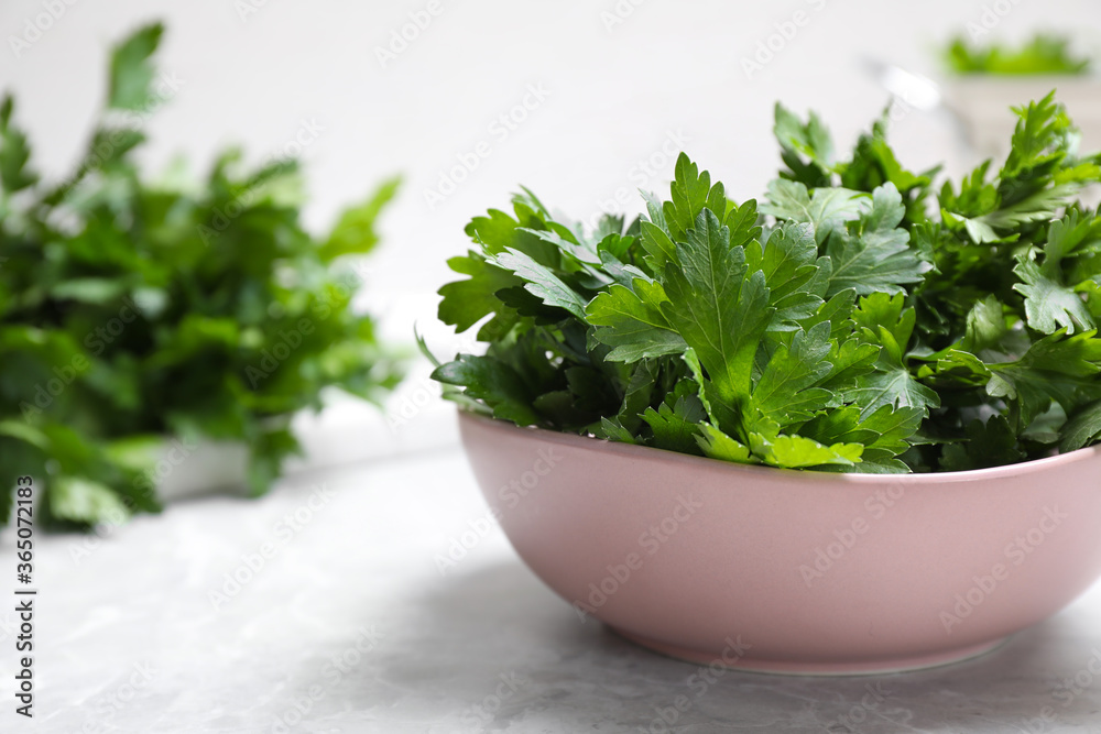 Fresh green parsley in bowl on white table, space for text Fresh green parsley in bowl on white table, space for text