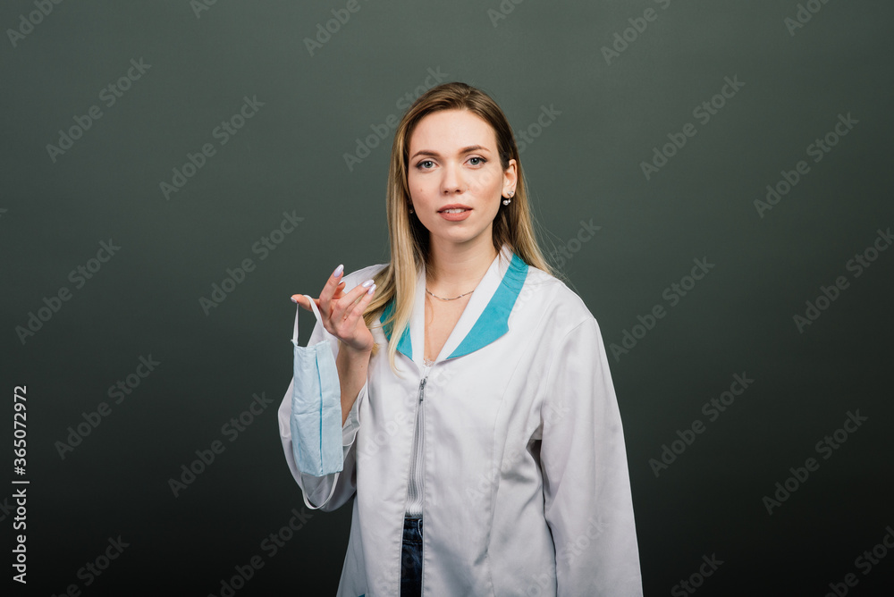 Female in medical dress with medical mask in hands. End of epidemic of coronavirus. Self-isolation with covid 19. Female in medical dress with medical mask in hands. End of epidemic of coronavirus. Self-isolation with covid 19.