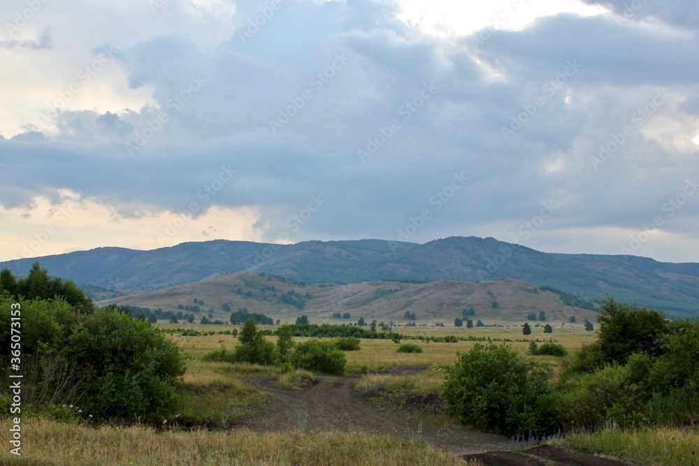 Summer landscape at sunset. Beautiful panoramic view on the mountains of fields and forests