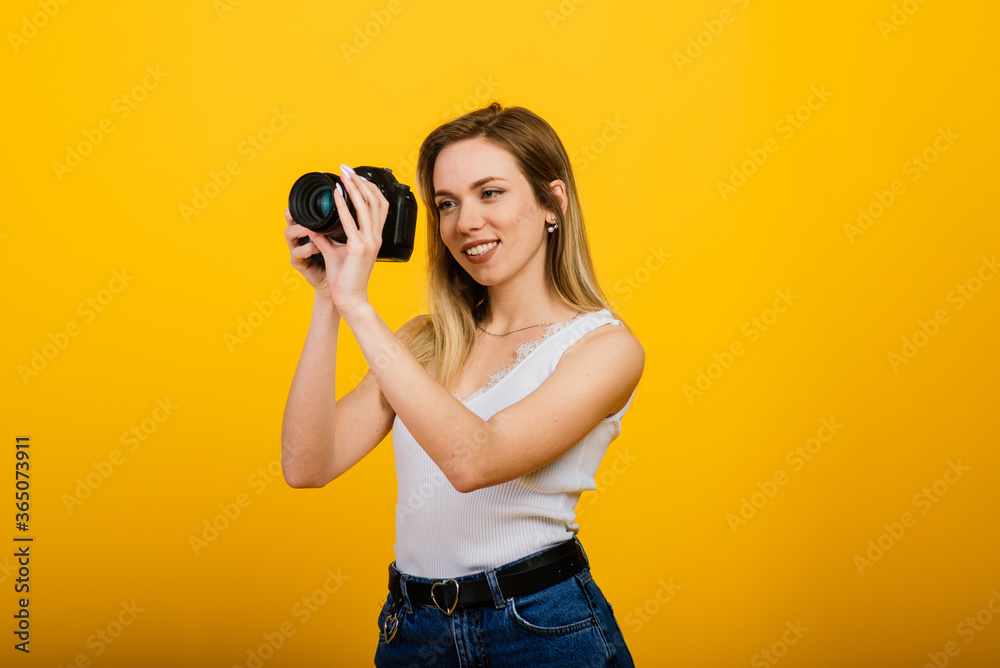 Excited female photographer working in studio. Portrait of stunning blonde girl with photo camera. Excited female photographer working in studio. Portrait of stunning blonde girl with photo camera.