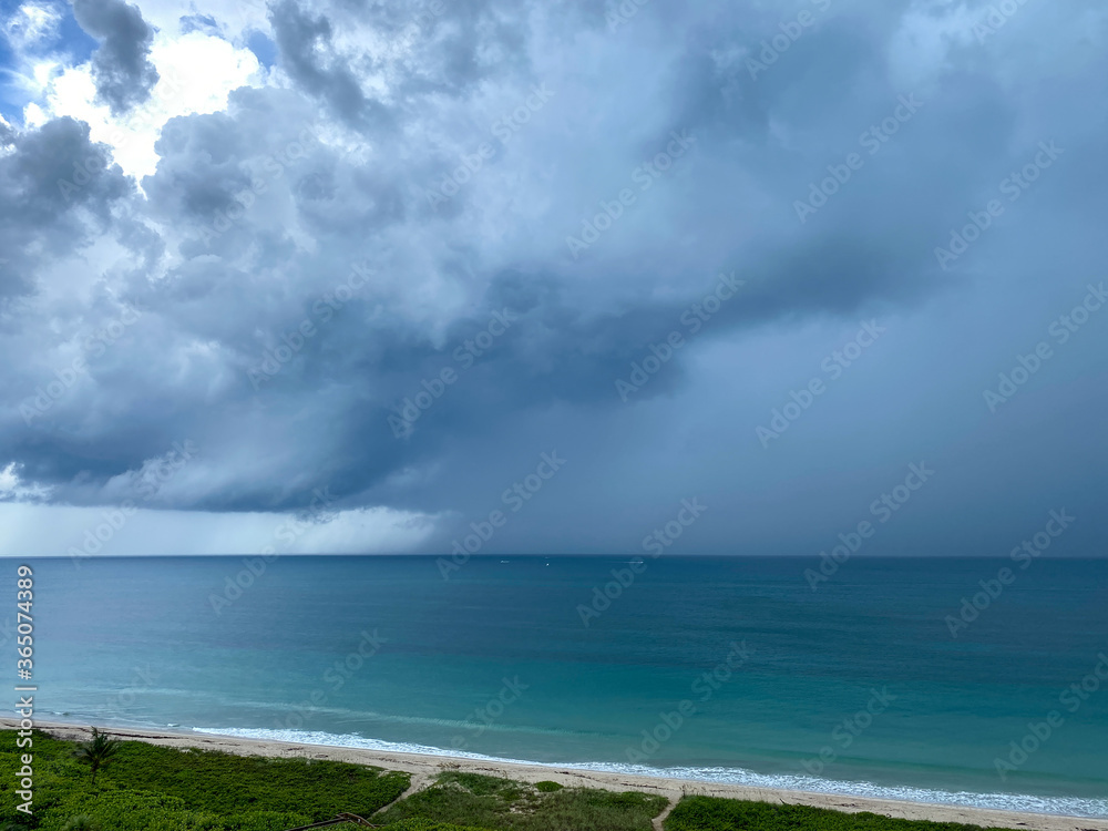 A storm over the colorful Atlantic Ocean with dark clouds.