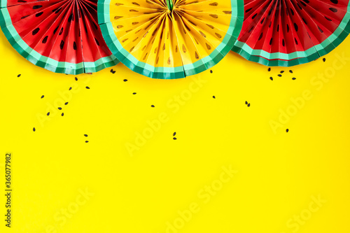Paper fruit origami watermelon fan decoration. Creative banner with copy space on bright yellow background. Tropics summer